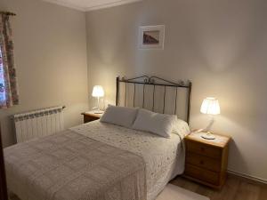 1 dormitorio con 1 cama y 2 lámparas en las mesas en Casa rural A Santiaga en Costa da Morte, en Cabana de Bergantiños