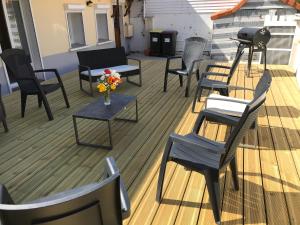 a group of chairs and tables on a deck at Longère entre terre et mer in Marquise