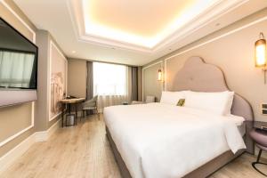 una camera con letto bianco e TV a schermo piatto di Mercure Xian City Centre a Xi'an Altre 43 foto