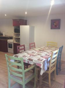 kuchnia ze stołem i krzesłami oraz kuchnia z lodówką w obiekcie Gites at Le Prielle w mieście Madiran
