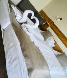 a large bed with white sheets and pillows at Xendala Panzió in Balatonakarattya