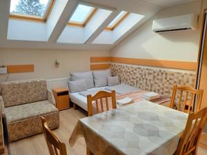 a room with a bed and a table and a couch at Bocskai Apartmanház in Hajdúszoboszló