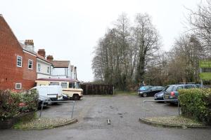 un estacionamiento con autos estacionados frente a una casa en Contractor friendly from 'TOBS Norwich' en Norwich