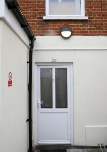 a white garage door with a window on a brick building at Contractor friendly from 'TOBS Norwich' in Norwich