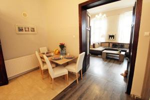 comedor con mesa y sillas y sala de estar en Apartament ToTu, en Toruń