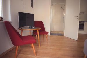 a living room with two chairs and a table with a television at See Appartements in Mörbisch am See