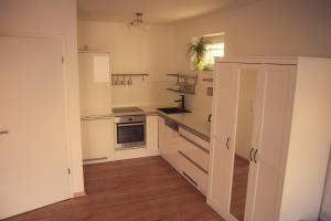 eine Küche mit weißen Schränken und einer Arbeitsplatte in der Unterkunft See Appartements in Mörbisch am See