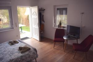 a bedroom with a bed and a desk and a television at See Appartements in Mörbisch am See