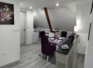 uma sala de jantar com uma mesa e cadeiras num quarto em Apartmani Zlatarski DAR em Nova Varos