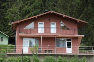 Cette maison rose dispose d'un balcon. dans l'établissement Вили Сара, à Orlino
