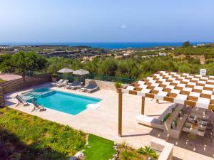 una vista aérea de una piscina con sillas y sombrilla en Estella Villa with Pool, Children Area, BBQ & Magnificent Views!, en Astérion