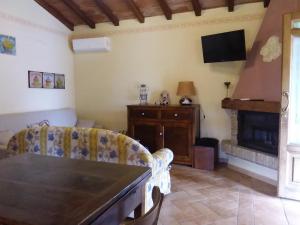 ein Wohnzimmer mit einem Tisch und einem Kamin in der Unterkunft Casa Gaia in Poggio Murella