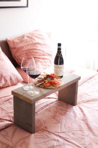 a table with two glasses of wine and a plate of food at Bed and Wine Nonsolovino in Reeuwijk