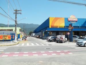 a street with cars parked in front of a building at Casa Caraguatatuba no Centro in Caraguatatuba
