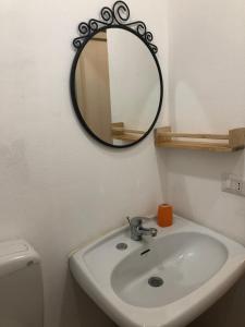 ein Bad mit einem Waschbecken und einem Wandspiegel in der Unterkunft Casa Relax Avola in Avola