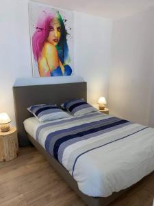 Schlafzimmer mit einem Bett mit Wandgemälde in der Unterkunft Le bruit des vagues in Berck-sur-Mer