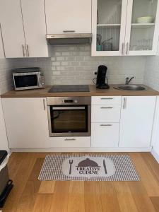 eine Küche mit weißen Schränken und einem Küchenteppich auf dem Boden in der Unterkunft Le bruit des vagues in Berck-sur-Mer