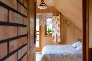 Schlafzimmer mit einem Bett und einem Fenster in der Unterkunft Kurpiowska Chatka in Stanisławowo