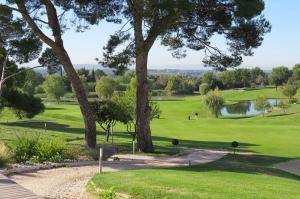 a view of a golf course with trees and a pond at chambre à Mazan, idéale calme et repos in Mazan