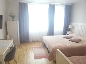 um quarto com 2 camas, uma secretária e uma janela em Nurmbergi Maja em Viljandi