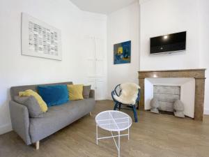 a living room with a couch and a fireplace at T2 Montpellier centre, climatisé in Montpellier