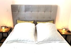 a bed with two white pillows and two lamps at T2 Montpellier centre, climatisé in Montpellier