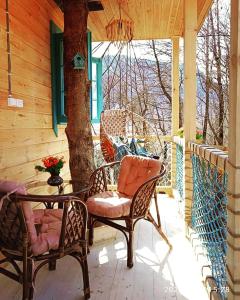 a patio with two chairs and a table on a porch at Garemo in Ambrolauri