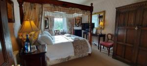 ein Schlafzimmer mit einem großen Bett mit Baldachin in der Unterkunft Glyn Isa Country House B&B and self catering Lodge in Conwy