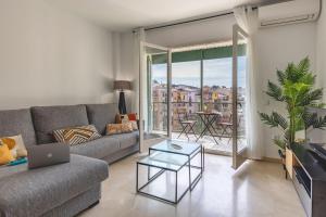 un soggiorno con divano, tavolo e finestra di Bravissimo Plaça de la Independència, Morning Sun a Girona