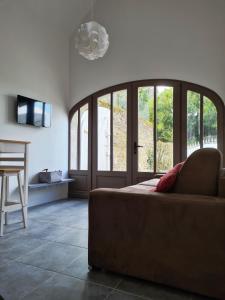 a living room with a couch and glass doors at Le Petit Logis in Bléré