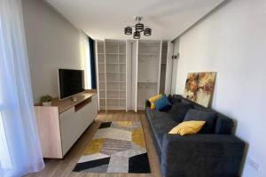 a living room with a couch and a flat screen tv at Cozy apartment in the Business area of Bucharest in Bucharest