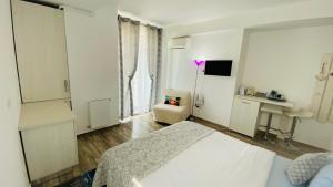 a white bedroom with a bed and a chair at Studio for 2 in Mamaia Summerland in Mamaia