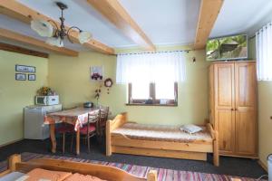 Cette chambre comprend une table, un lit et une salle à manger. dans l'établissement Drevenica MAK Kristián, à Kvačany