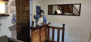 a woman standing at a counter with a mask on at Gîte ULTREIA in Saint-Jean-Pied-de-Port