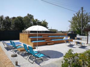 eine Gruppe Stühle und ein Sonnenschirm auf einer Terrasse in der Unterkunft Villa Roma Holidays in Jesolo