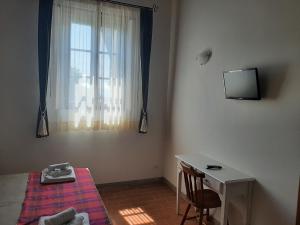 Schlafzimmer mit einem Bett, einem Schreibtisch und einem Fenster in der Unterkunft Agriturismo Il Frantoio Di Colle Alberto in Montale