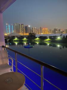 a balcony with a view of a river at night at C Hotel in Manama