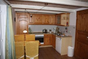 a kitchen with wooden cabinets and a stove top oven at Schleikate in Winnemark