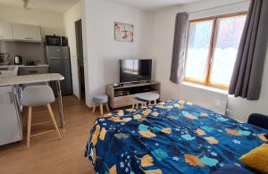 a small bedroom with a bed and a kitchen at La Cabane de Fierville in Fierville-les-Parcs