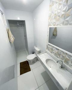 uma casa de banho branca com um lavatório e um WC em Casa em Peroba/Maragogi 100m da Praia em Ponta do Mangue