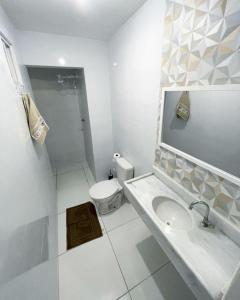 a white bathroom with a sink and a toilet at Casa em Peroba/Maragogi 100m da Praia in Ponta do Mangue