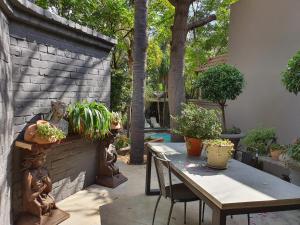 een patio met een tafel en een aantal potplanten bij Waterhouse Guest Lodge - Indus Street in Pretoria