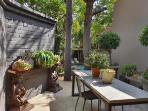 a patio with a table and some potted plants at Waterhouse Guest Lodge - Indus Street in Pretoria