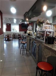 a restaurant with a bar with stools and a counter at Hotel A Forxa Cafetería Restaurante in Carballeira