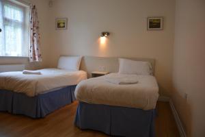 - 2 lits dans une petite chambre avec fenêtre dans l'établissement Aghadoe Country Cottage, à Killarney