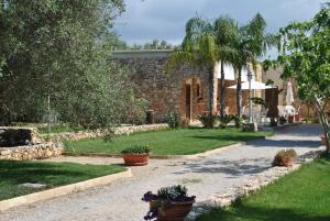 Casa de piedra con jardín con macetas en Borgo Console, en Porto Cesareo