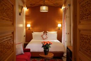 Habitación de hotel con cama y silla roja en Elegancia Riad Boutique & SPA en Marrakech