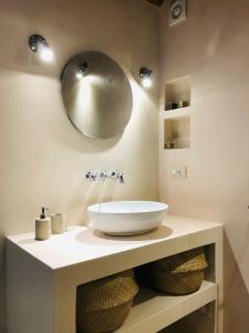 uma casa de banho com um lavatório e um espelho na parede em O'scià Loft em Noto