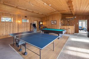 a ping pong table in a room with wooden walls at Hardanger Guesthouse in Ulvik