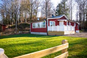 a red and white house in a yard with a fence at Almas gård in Ullared
